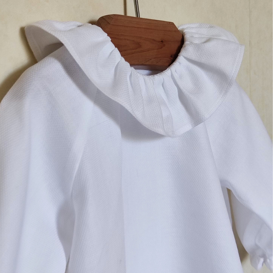 La blouse blanche à col volanté